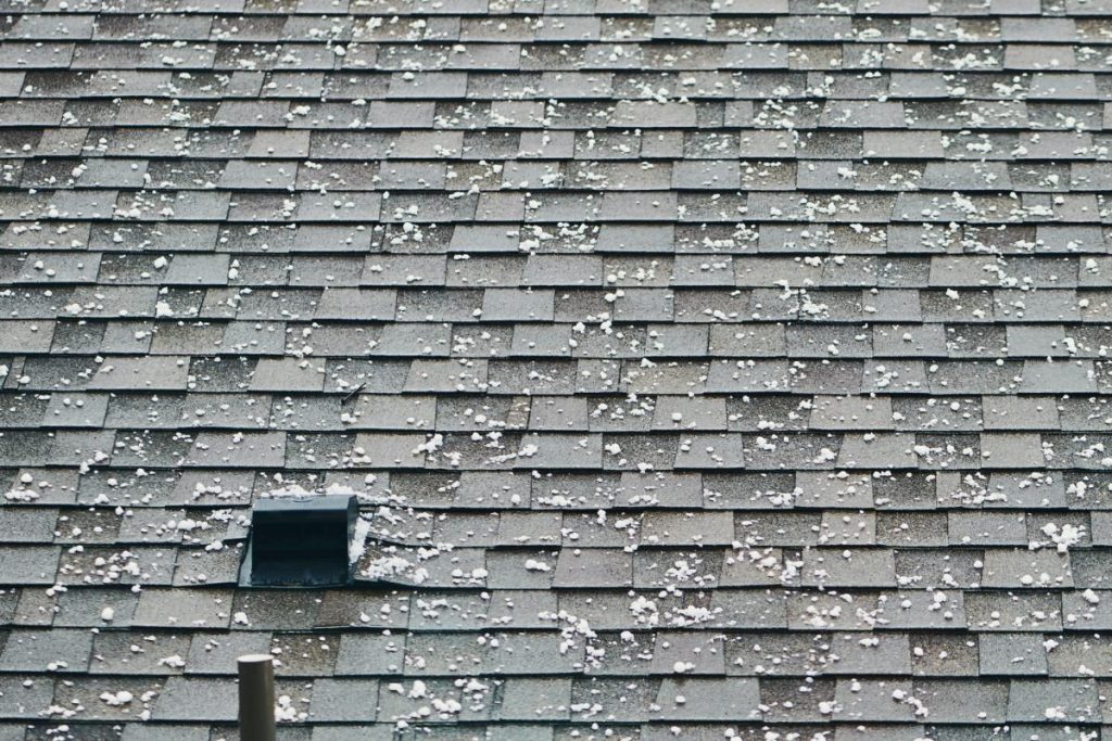 Close-up of hail-damaged asphalt shingles on a residential roof in Greeley, Colorado