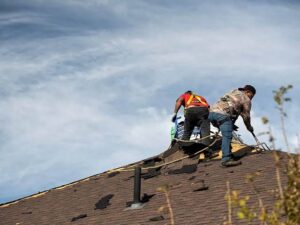 Residential roof being repaired after hail damage with Boulder, Colorado foothills in the background