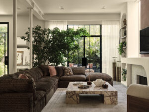 A living room with a couch and a table with a plant in the corner
