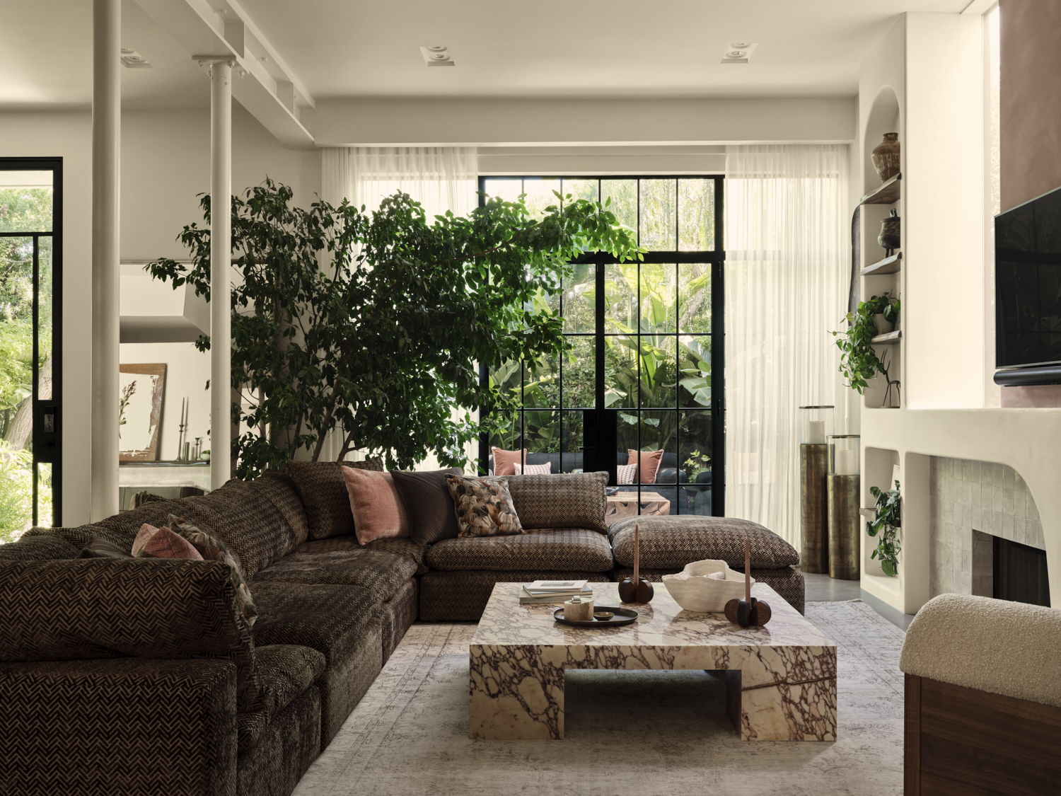 A living room with a couch and a table with a plant in the corner